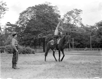 Paul Cozé te paard met draaiende lasso een cowboy staat er naast, Bestanddeelnr 190-0771