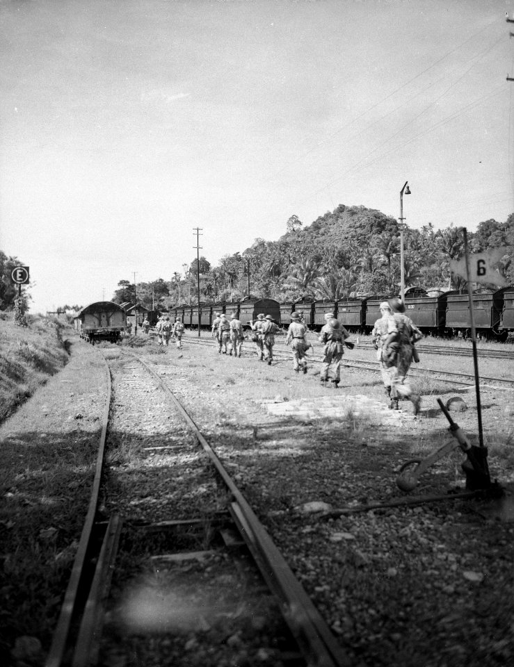Patrouille langs spoorlijn op spoorwegemplacement Rechts kolenwagons, Bestanddeelnr 10544