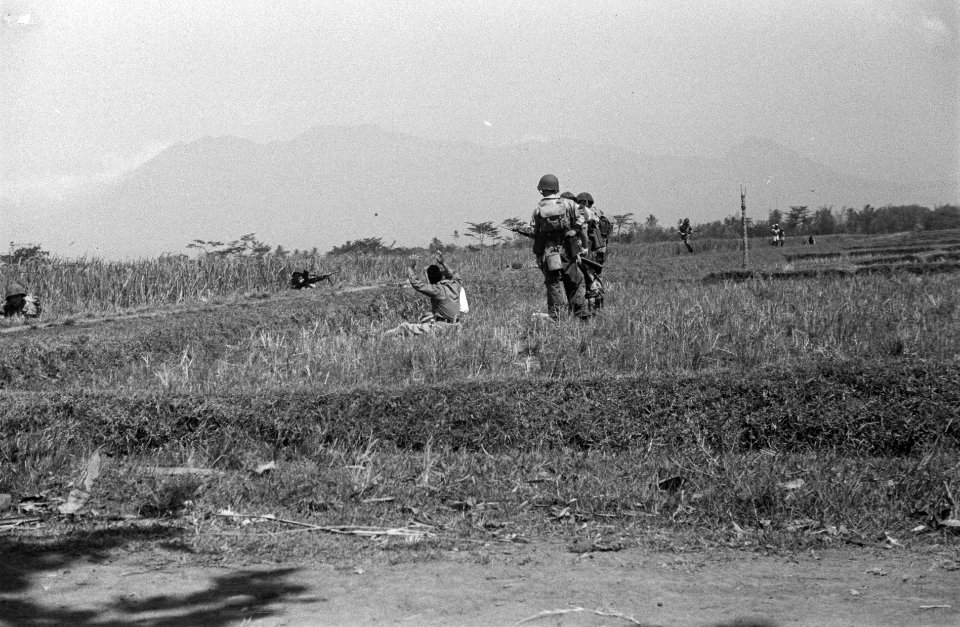 Patrouillegang. Een Indonesische man zit in een rijstveld en houdt zijn armen om, Bestanddeelnr 6628