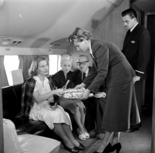Passagiers in een vliegtuig krijgen eten aangeboden, Bestanddeelnr 252-2058