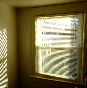 Pattern of light on wall by sun through blinds plus window photo