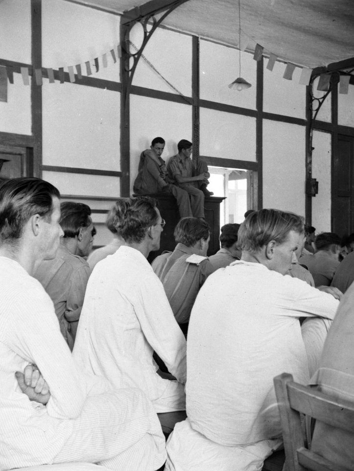 Patiënten van een militair hospitaal zitten in een versierde zaal, Bestanddeelnr 13556