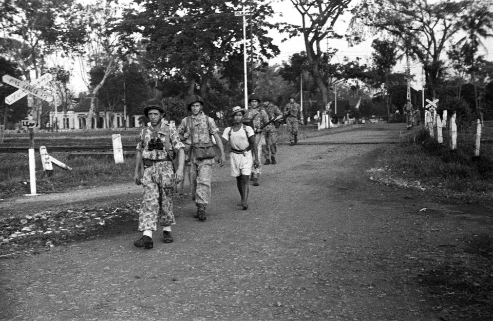 Patrouillegang. Sectie steekt spoorwegovergang over. Bij hen een Indonesische jo, Bestanddeelnr 6616
