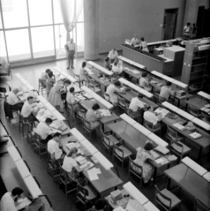 Overzichtsfoto van bovenaf genomen met studenten aan leestafels in een universit, Bestanddeelnr 255-2425