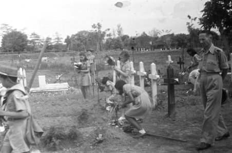 Padvinders en padvindsters leggen bloemen op de graven. Rechts een luitenant-kol, Bestanddeelnr 486-4-1