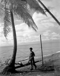 Padang Een schildwacht bij het strand Achter hem prikkeldraad, Bestanddeelnr 10458