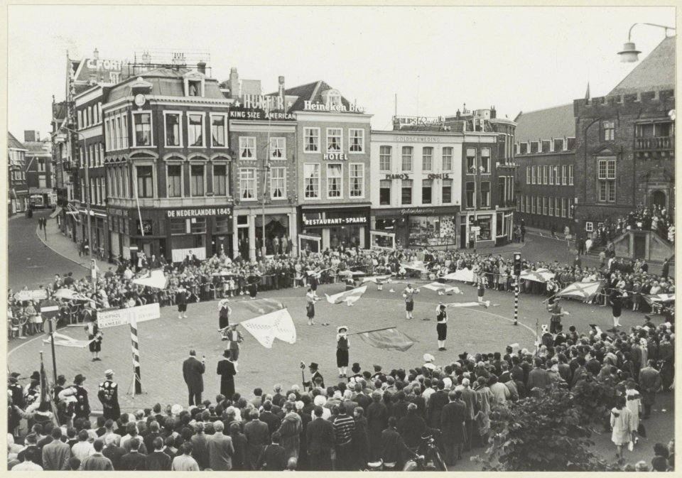 Overzicht van de Grote Markt tijdens een demonstratie vendelzwaaien, ziende naar het zuidwesten. NL-HlmNHA 54004381