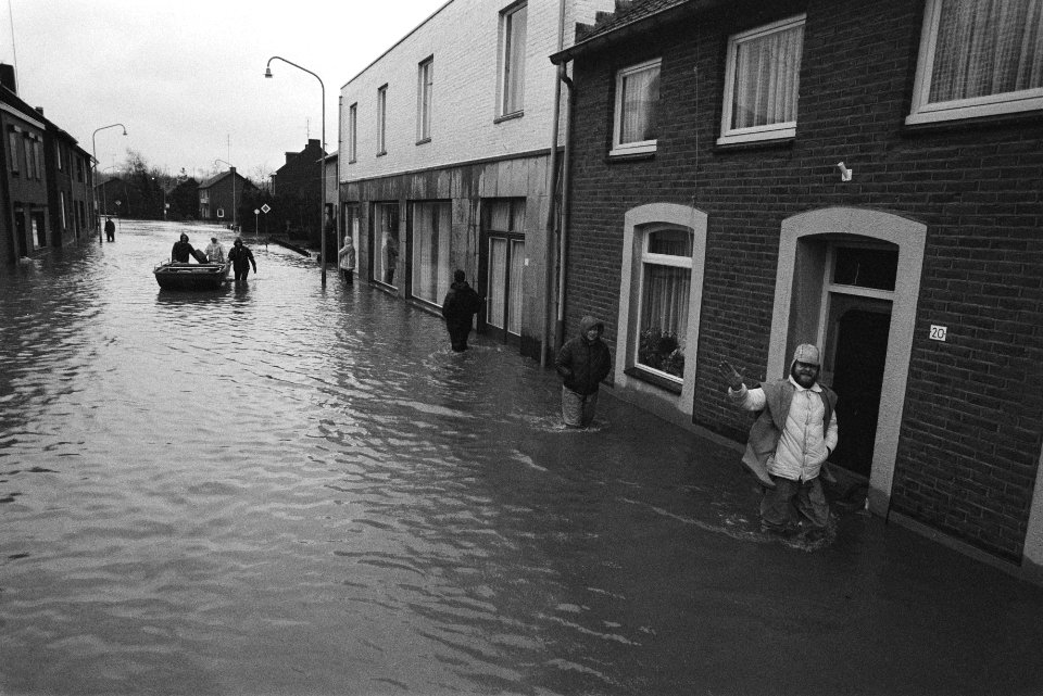 Overstromingen in Limburg in het dorpje Itteren bewoners waden langs hun huizen, Bestanddeelnr 932-8625