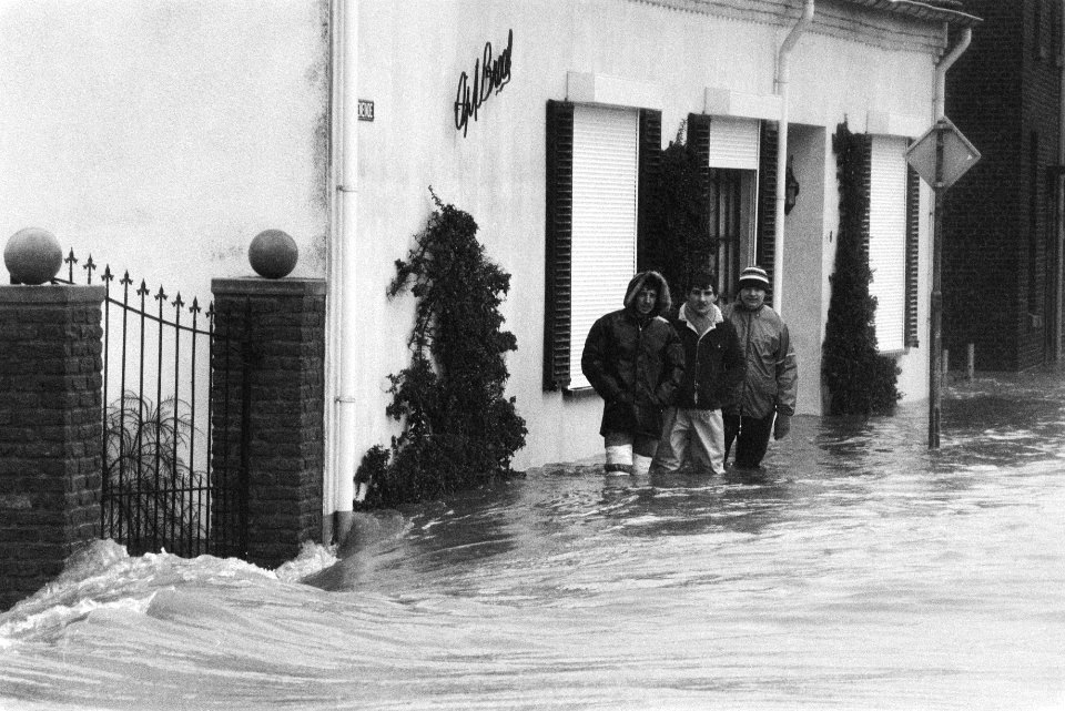 Overstromingen in Limburg in het dorpje Itteren bewoners waden langs hun huizen, Bestanddeelnr 932-8626