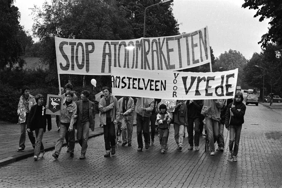 Overzicht van de optocht met spandoeken waaronder Stop atoomraketten, Bestanddeelnr 931-7056