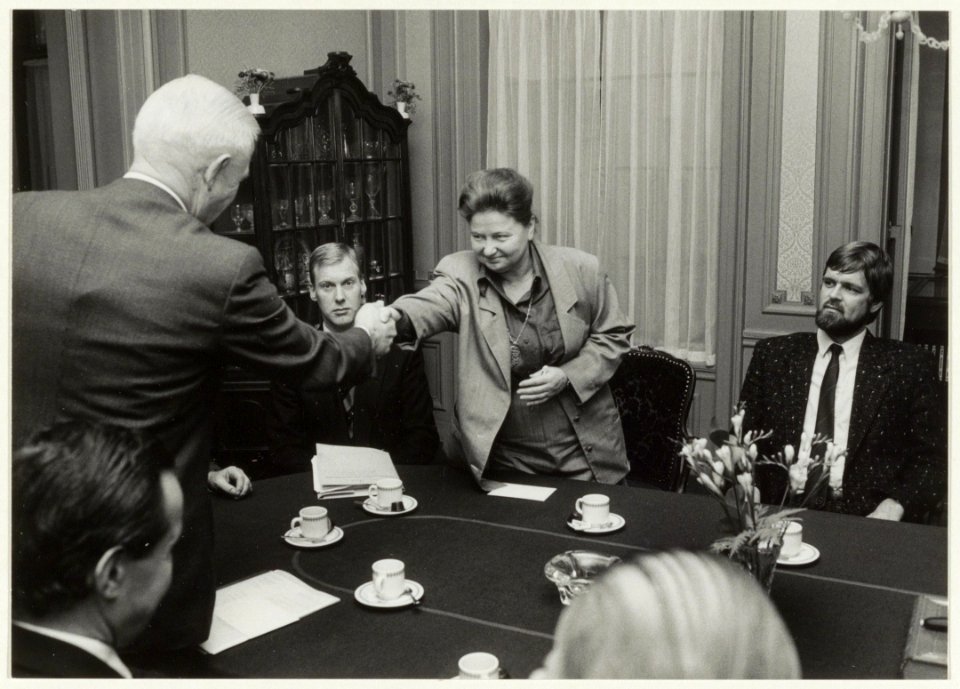 Overdracht van het gebouwencomplex van de Fa. Enschedé aan de Gemeente Haarlem. Directeur Ir. D.J. Enschedé feliciteert burgemeester E.M. Schmitz. Rechts wethouder Wiebe koster. NL-HlmNHA 54020735