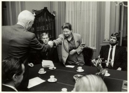 Overdracht van het gebouwencomplex van de Fa. Enschedé aan de Gemeente Haarlem. Directeur Ir. D.J. Enschedé feliciteert burgemeester E.M. Schmitz. Rechts wethouder Wiebe koster. NL-HlmNHA 54020735
