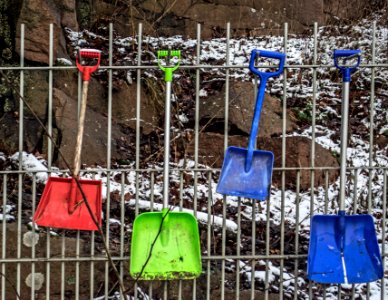Plastic shovels hanging on fence