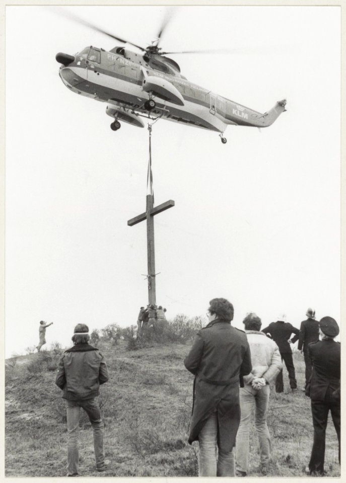 Plaatsing per helicopter van nieuw houten kruis op de Erebegraafplaats, nadat het vorige door blikseminslag werd vernield. NL-HlmNHA 54004821