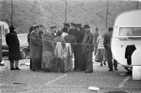 Politieagenten zijn in gesprek met een aantal zigeuners, rechts een caravan, Bestanddeelnr 926-9297