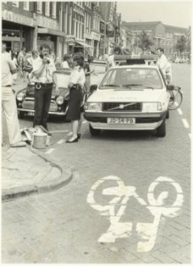Politieagenten met portofoon in aktie voor de deur van supermarkt De Kijkgrijp. Gedempte Oude Gracht 56, NL-HlmNHA 54016785