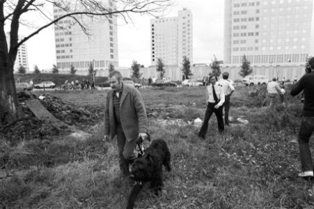 Politieagenten en een hondengeleider met een politiehond voor de gebouwen van de, Bestanddeelnr 931-6473