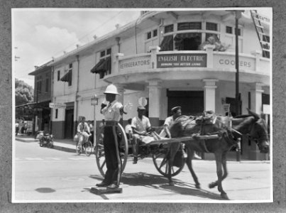 Politieagent en paard en wagen in Kingston op Jamaica. Op de achtergrond in wink, Bestanddeelnr 252-5387