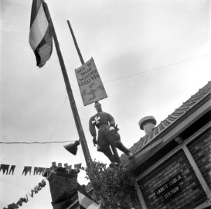Pop voorstellende Hitler hangt aan een paal met opschrift was ik maar schilder, Bestanddeelnr 900-4559