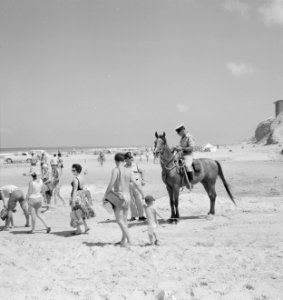 Politieman te paard en badgasten aan het strand, Bestanddeelnr 255-2913