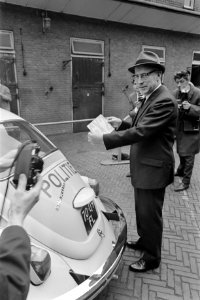 Politie nu 6x2. Burgemeester Samkalden plakt nieuwe alarmnummer op auto, Bestanddeelnr 921-3397