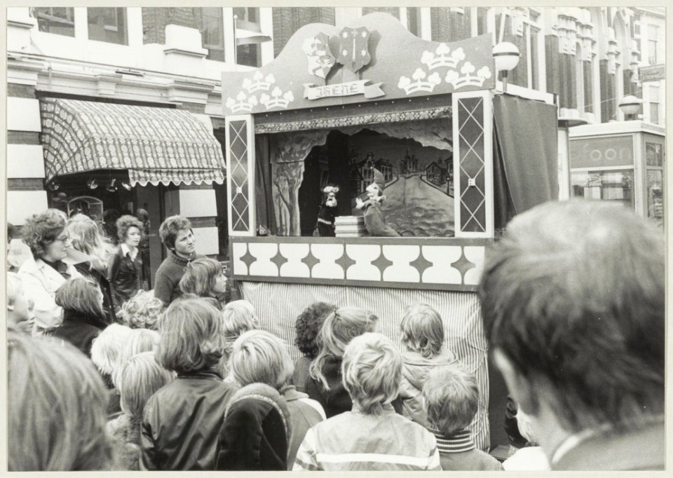 Poppenkast in de Grote Houtstraat tussen de Grote Markt en de Spekstraat. NL-HlmNHA 54009600