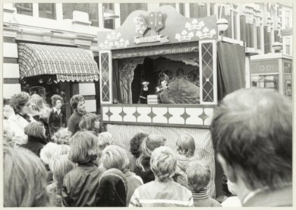 Poppenkast in de Grote Houtstraat tussen de Grote Markt en de Spekstraat. NL-HlmNHA 54009600