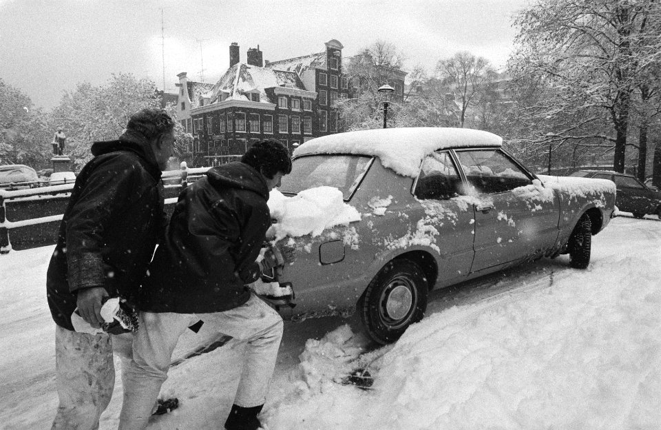Plotselinge hevige sneeuwval, twee voorbijgangers geven auto duwtje om over een , Bestanddeelnr 931-1333