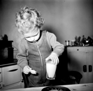 Peuter zet een glas melk op tafel, Bestanddeelnr 252-9381