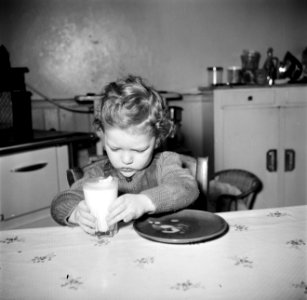 Peuter tijdens het op tafel zetten van een glas melk, Bestanddeelnr 252-9383