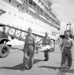 Per brancard aan boord van het MS Oranje brengen van een gewonde ter repatriërin, Bestanddeelnr 255-6768