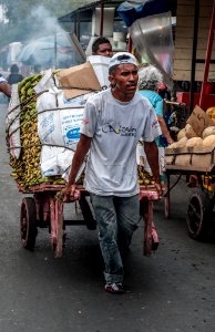 Person carrying utensils for sale on a cart photo