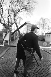 Personeel van de basis brengt een vrouw op die over het hek is geklommen, Bestanddeelnr 932-8030