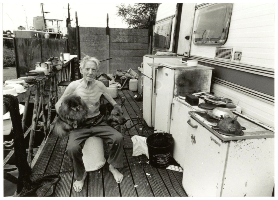 Piet Snel op het steiger van zijn caravan samen met zijn honden. Terrein van het voormalige Conrad Stork. NL-HlmNHA 54035309
