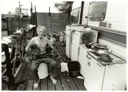 Piet Snel op het steiger van zijn caravan samen met zijn honden. Terrein van het voormalige Conrad Stork. NL-HlmNHA 54035309