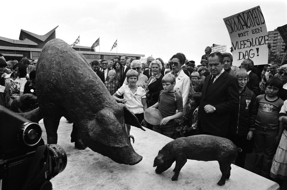 Pierre Lardinois bij het monument op de achtergrond een demonstratie tegen de b, Bestanddeelnr 930-3052