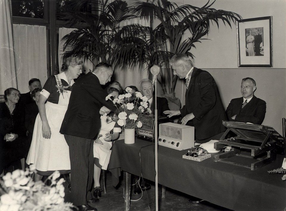 Sanatorium Brederodeduin bestond 25 jaar op 27 september 1952. Oudpatienten boden de voorzitter van het bestuur Dr. O.H. Dijkstra (2de van rechts) een radio aan. Aangekocht van fotograaf C. , NL-HlmNHA 1478 25900 K 38