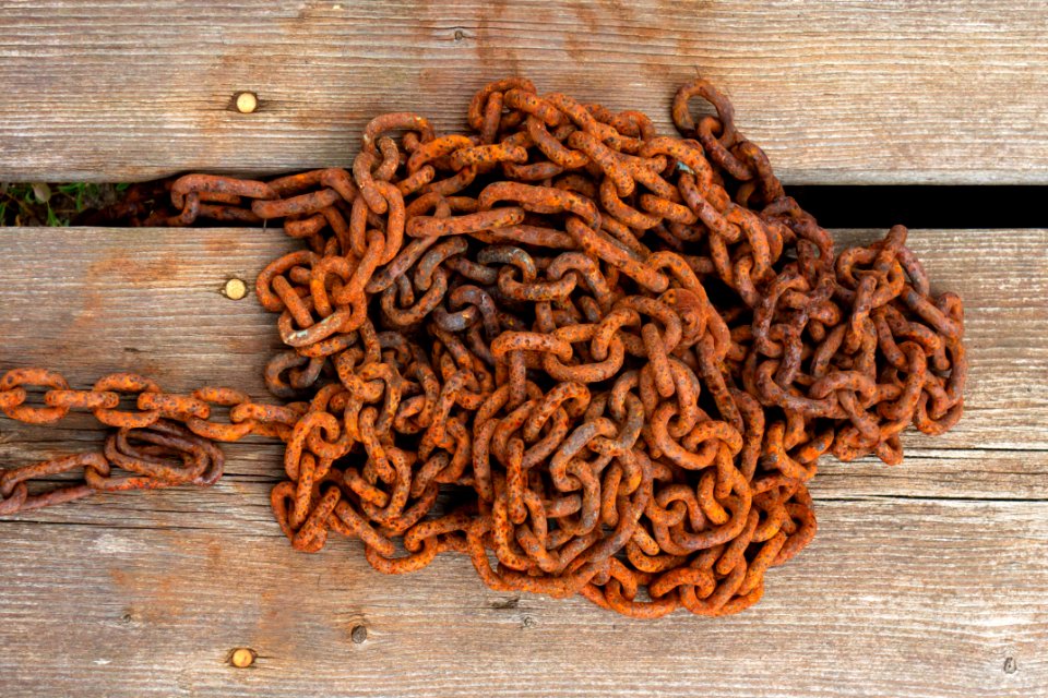 Rusty chain on wooden deck in Loddebo