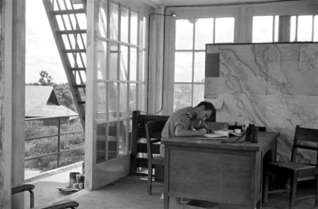 Ruimte in de verkeerstoren waar een KNIL sergeant bezig is aan een bureau met ad, Bestanddeelnr 1508