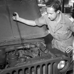 Sergeant meet oliepeil van motor van een jeep, Bestanddeelnr 6963