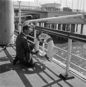 Serie over nieuwe Pier in Scheveningen Arbeider bevestigt reddingsboei, Bestanddeelnr 912-5016