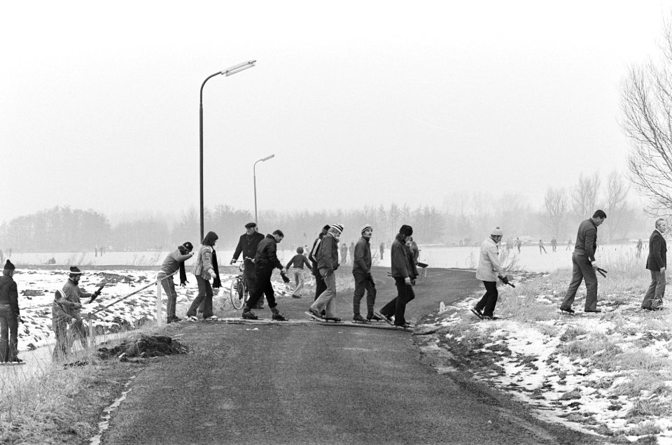 Schaatstocht Uithoorn naar De Kwakel (ondanks dooi) deelnemers steken dijk over, Bestanddeelnr 928-4059