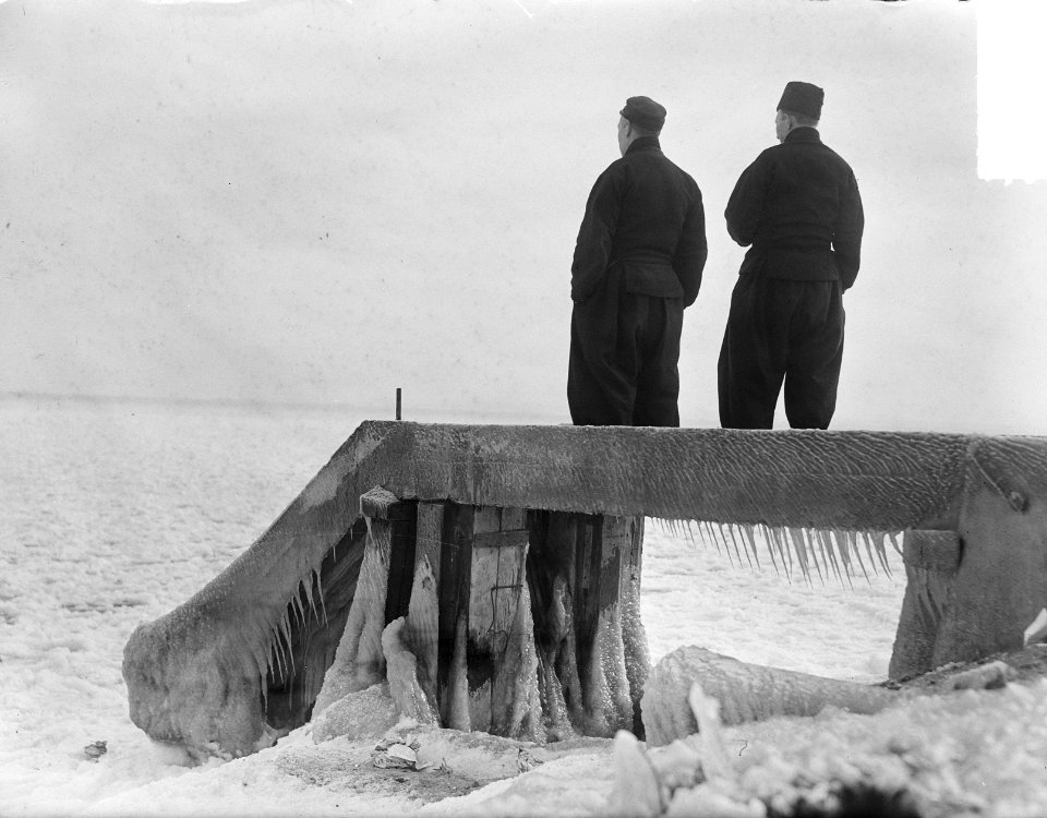Schaatsen in Volendam. Mannen kijken uit over de Gouwzee, Bestanddeelnr 903-8039