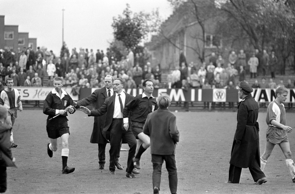 Scheidsrecher Schalks en één van de grensrechters haasten zich het veld af, Bestanddeelnr 919-6556