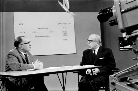 Schooltelevisie Jaap Buys geeft uiteenzetting in gesprek met dhr Souren (rechts, Bestanddeelnr 915-6377