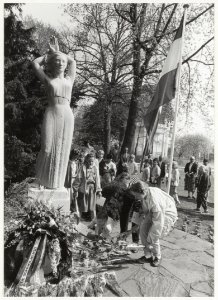 Schoolkinderen leggen bloemen bij de oorlogsmonumenten. NL-HlmNHA 54015319