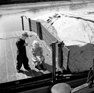 Schipperskinderen Wim van Geijn en Elly Werner snoepend aan boord in de haven v…, Bestanddeelnr 254-1651