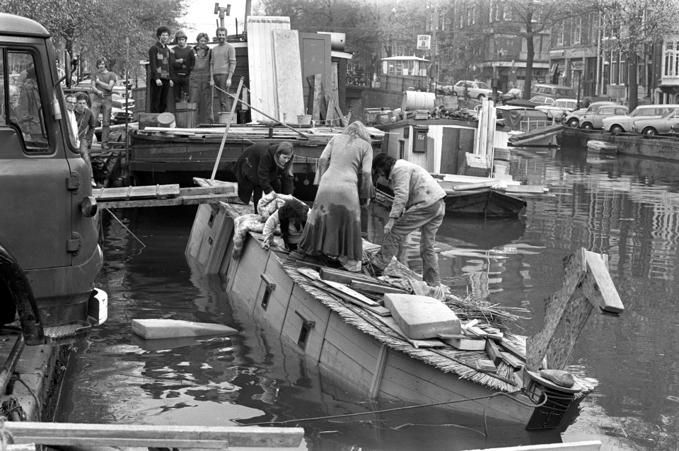 Schipbreuk in Amsterdamse grachten, hippies op dak woonboot, Bestanddeelnr 925-9892