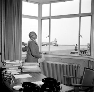 Schiphol-directeur Jan Dellaert aan zijn bureau op de luchthaven. Op de achtergr, Bestanddeelnr 254-2467