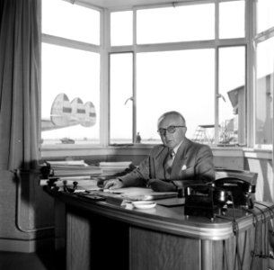 Schiphol-directeur Jan Dellaert aan zijn bureau op de luchthaven. Op de achtergr, Bestanddeelnr 254-2466